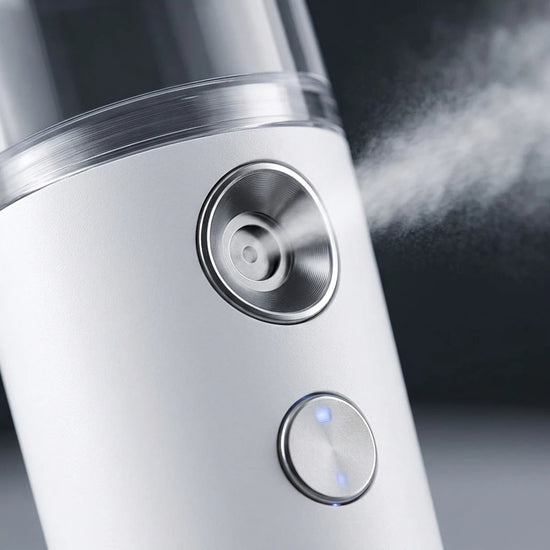 Close-up of a mini nano mist facial steamer showing mist diffusion for skin hydration.