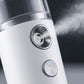 Close-up of a mini nano mist facial steamer showing mist diffusion for skin hydration.